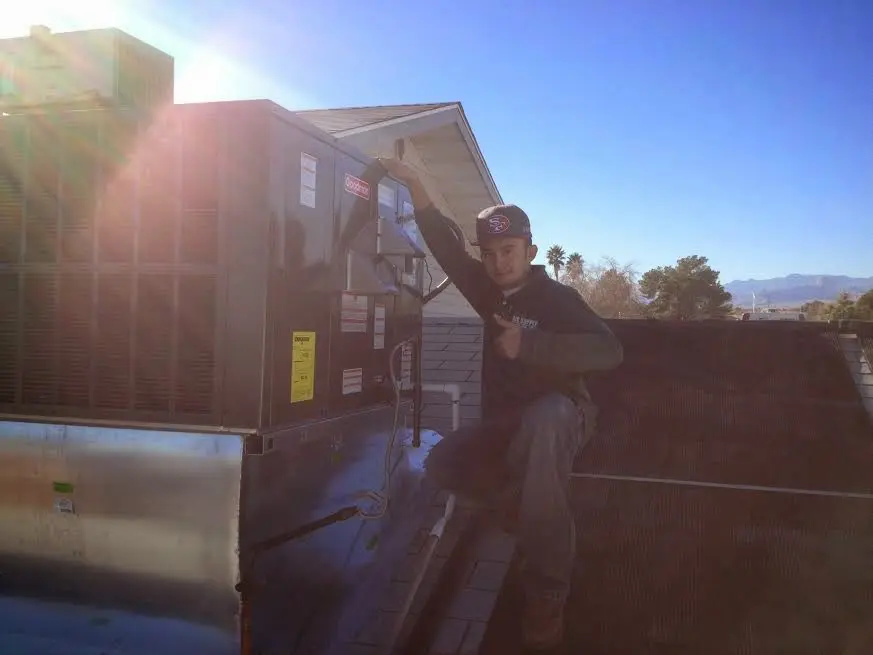 HVAC technician performing HVAC Inspection on a rooftop unit in Moss Point